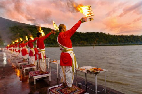 Rishikesh, Uttarakhand - August 03 2016: Priests in red robe in the holy city of Rishikesh in Uttarakhand, India during the evening light ceremony called Ganga arthi to worship river Ganga / Ganges.